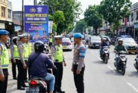 Petugas kepolisian didampingi Provos menggelar Operasi Patuh 2026 secara humanis di jalan raya.(ilustrasi poto: AI).