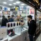 Ilustarsi Seorang pemuda melihat kotak iPhone 18 yang dipajang di etalase toko elektronik Charsou Mall, Teheran.(poto: AI).