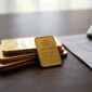Emas batangan Antam di atas meja kerja berdampingan dengan catatan harga dan kalkulator untuk menghitung nilai investasi.(poto: AI).