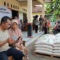 Ilustrasi Warga memeriksa status penerimaan bansos beras 30 kg lewat ponsel pakai NIK KTP di balai desa.(poto: AI).