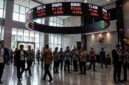 Layar ticker BEI memerah saat IHSG sesi I anjlok 1 persen di tengah aksi jual bersih investor asing, Senin (26/10/2026).(poto: AI).
