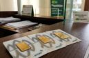 Emas batangan Antam tersusun di meja kasir Pegadaian, siap ditransaksikan nasabah dengan harga jual dan buyback baru.(poto: AI).