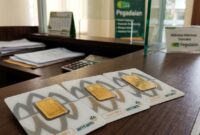 Emas batangan Antam tersusun di meja kasir Pegadaian, siap ditransaksikan nasabah dengan harga jual dan buyback baru.(poto: AI).