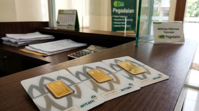 Emas batangan Antam tersusun di meja kasir Pegadaian, siap ditransaksikan nasabah dengan harga jual dan buyback baru.(poto: AI).